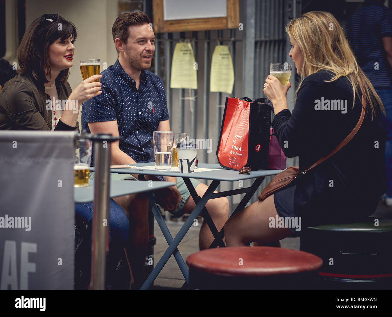 London, UK June, 2018. Young people enjoying drinks outside a pub