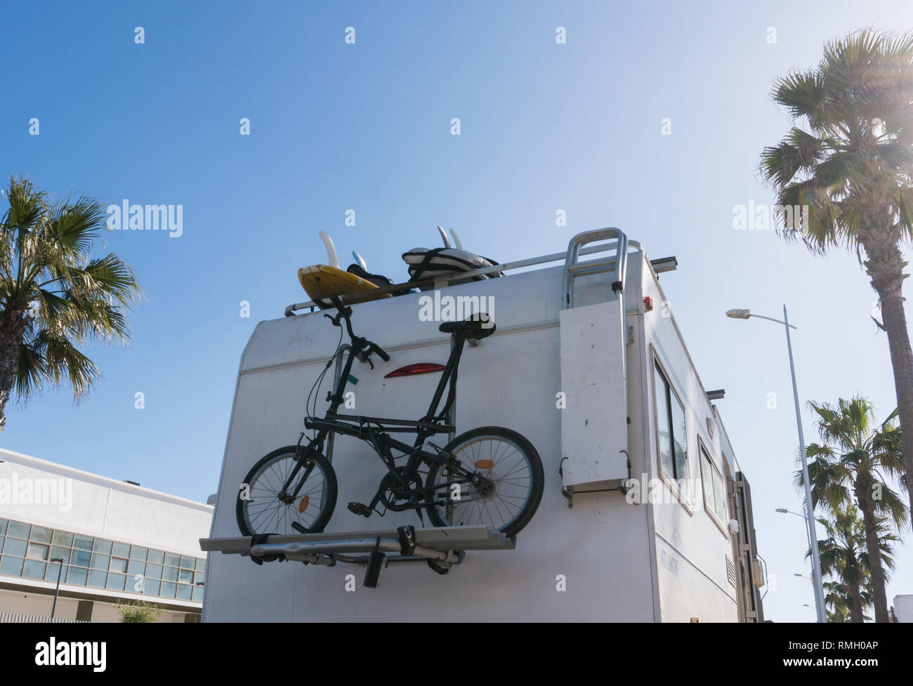 Cycle Car Rv RV White Camper Car with bicycles on Road surrounded with Palm trees ...