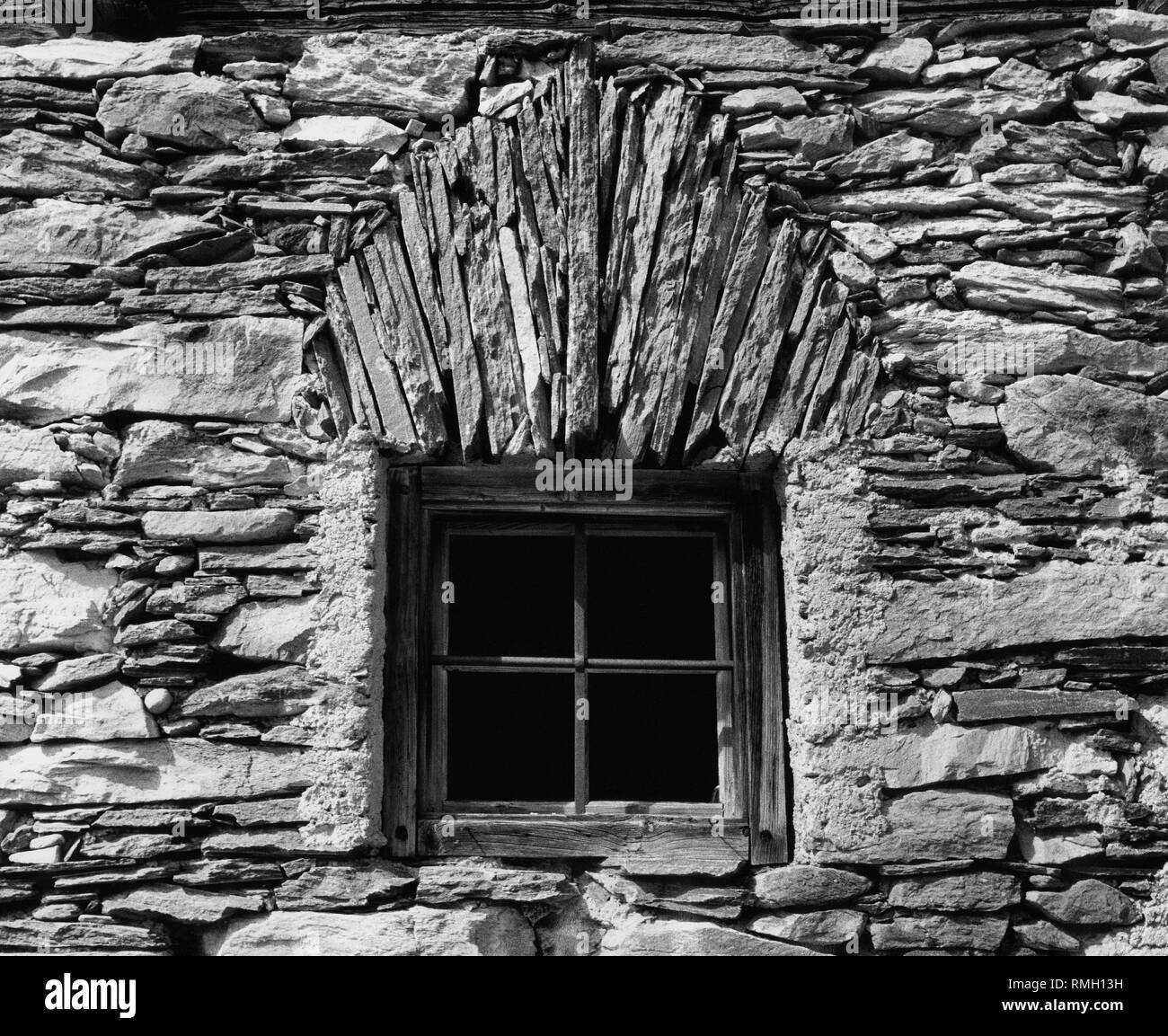 Stone facade with a wooden window . Undated picture Stock Photo - Alamy