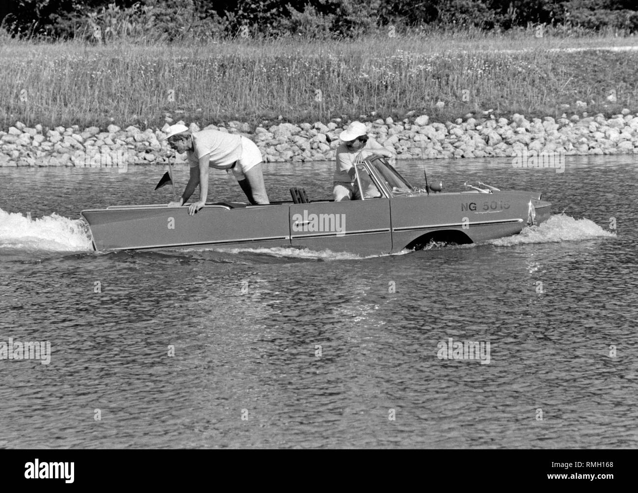 An Amphicar 770 drives on a body of water. The Amphicar, designed by Hans Trippel, was a four-seater amphibious vehicle, of which there were about 4000 pieces produced. Stock Photo