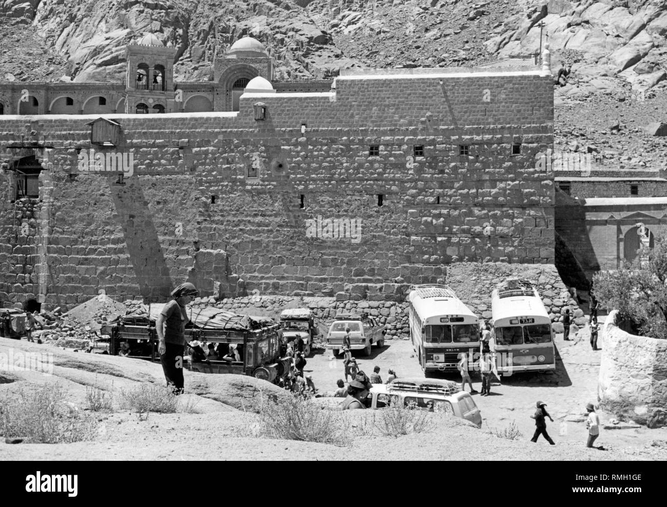Buses with tourists park in front of the St. Catherine's Monastery on the Sinai in today's Egypt. St. Catherine's Monastery is the oldest inhabited Christian monastery. The photo was taken under Israeli occupation of the Sinai. Israel occupied the peninsula twice: after the Suez Crisis in 1956, and from 1967 to 1982 as a result of the Six-Day War. Stock Photo