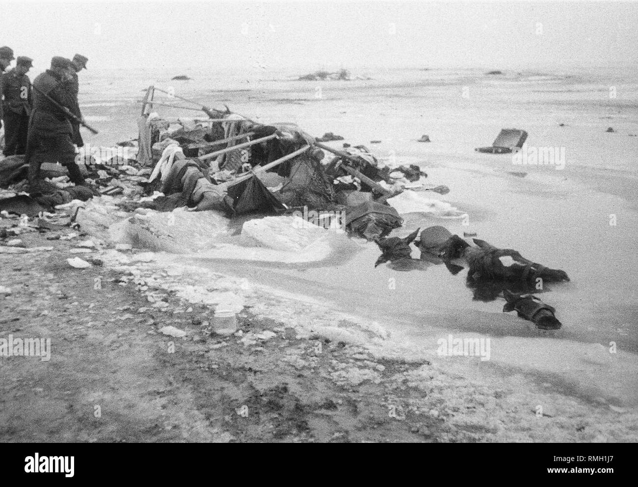 Soldiers at a wagon under which the ice has broken, the horses of which have died in an ice hole. At the beginning of February 1945, refugees trapped in the cauldron of East Prussia attempt to flee over the ice of the Fresh Bay to the Vistula Spit in order to reach along the Baltic Sea coast of Gdansk. The picture was taken by Theodor Vonolfen, a soldier of a Luftwaffe unit, deployed there at that time. Stock Photo
