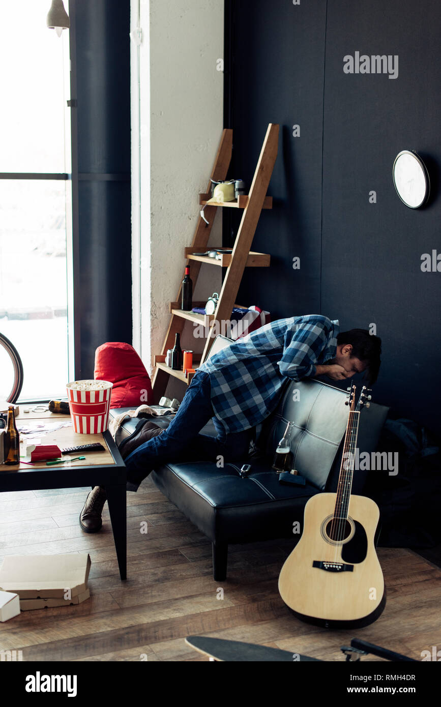 Drunk Man Feeling Nauseated After Party In Messy Living Room