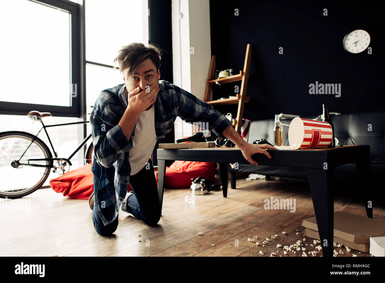 drunk man feeling nauseated while covering mouth at home after party