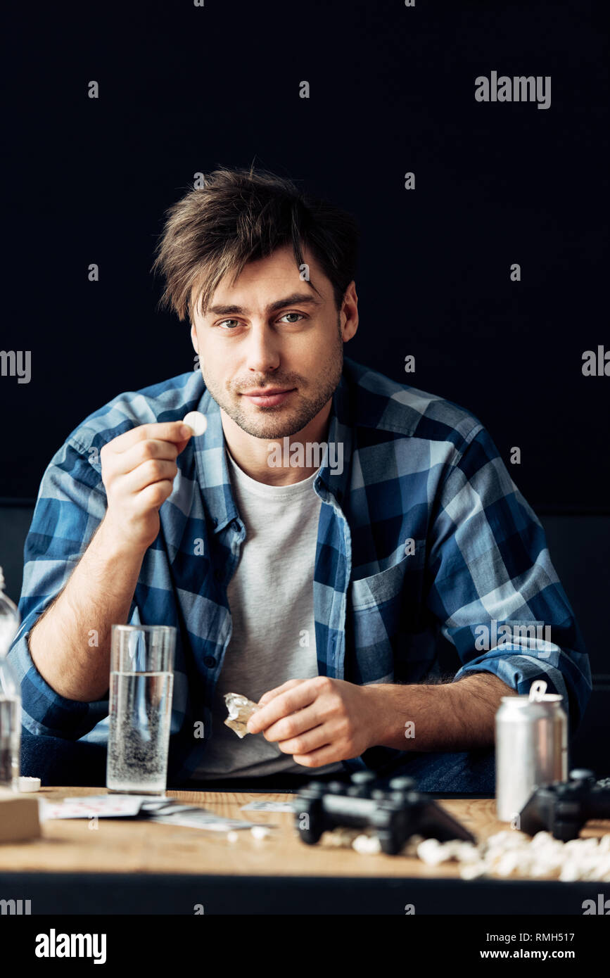 man suffering from hangover holding aspirin and glass of water in hands Stock Photo Alamy