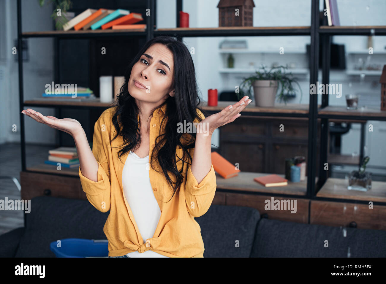 Confused Woman Standing With Hands Up Under Leaking Ceiling