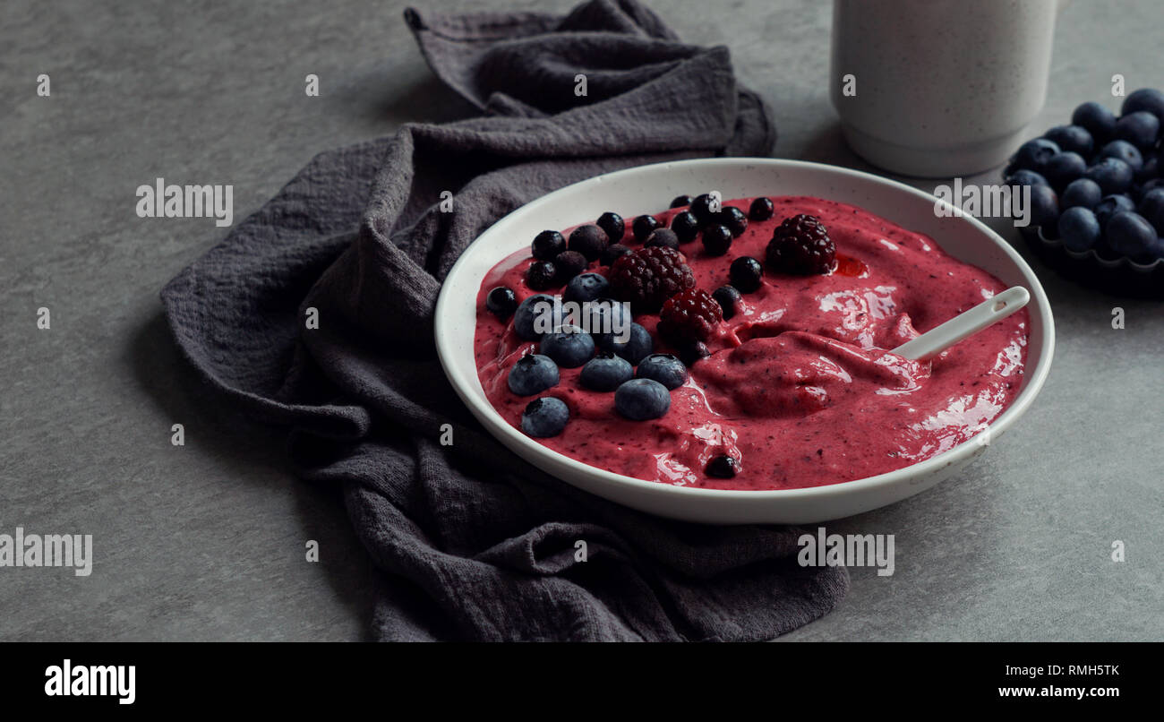 Smoothy of fresh bog blueberries and raspberries in bowl near napkin Stock Photo