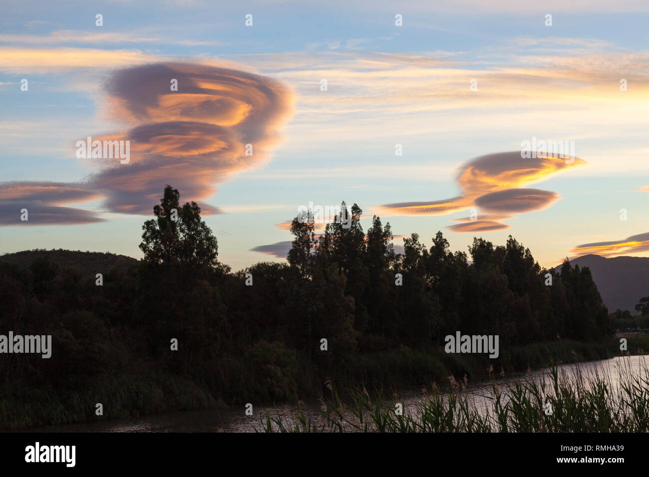 Lenticular clouds at sunset, Breede River Valley, Robertson, Western Cape, Hogh altitude lens-shaped stationary clouds, atmospheric waves, wind, turbu Stock Photo