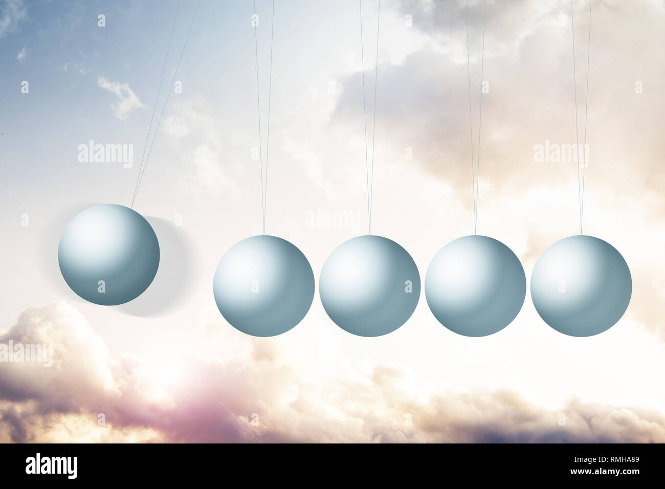 Newton’s cradle on a fantasy background with beautiful clouds and warm