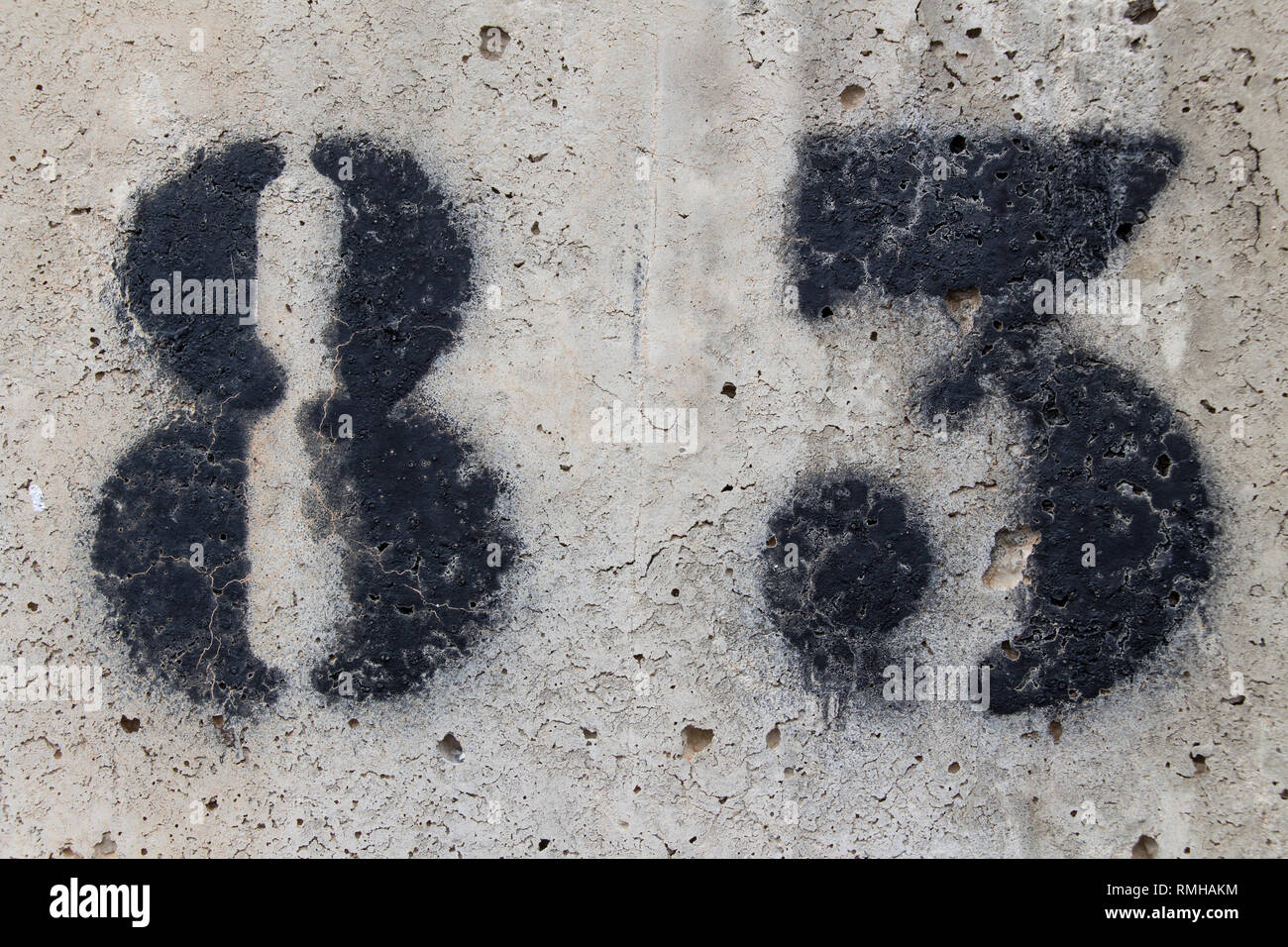 number eighty three painted stencil on concrete wall, number 83 Stock Photo