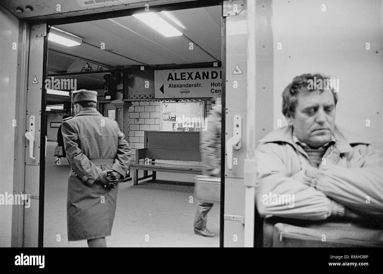 Germany, Berlin, 6 February, 1989: subway station Alexanderplatz, in the subway to Pankow. Sleeping man and an exiting NVA officer. Stock Photo