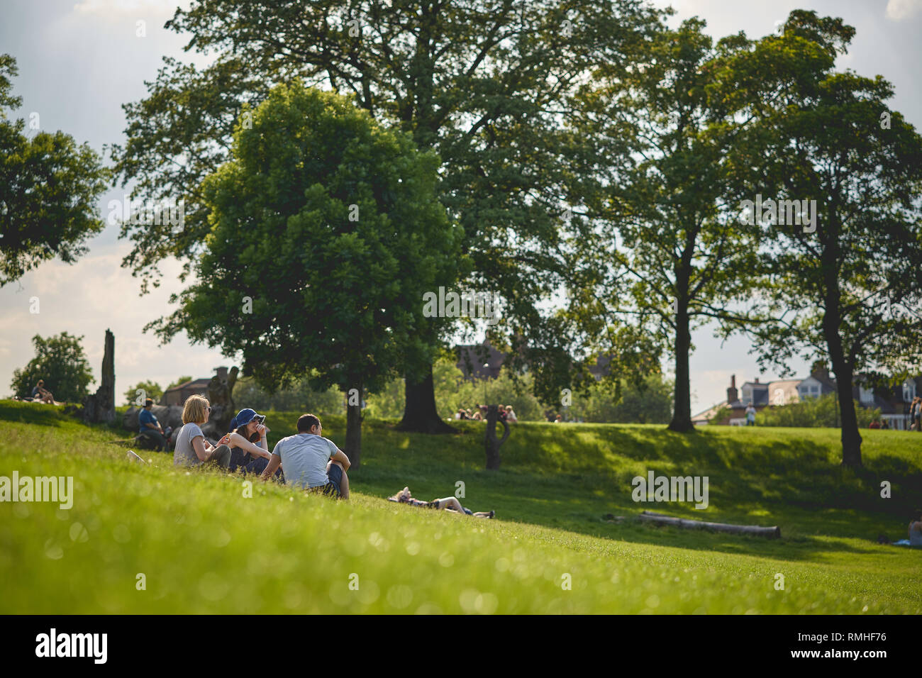 London, UK - February, 2019. Young people sitting in a park in South-East London. Stock Photo