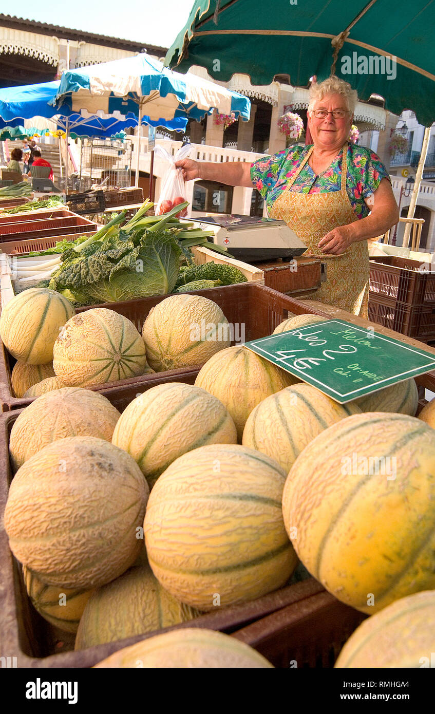 Woman stallholder selling melons in the street market in the town of Bram, near Castelnaudary and Canal du Midi Southern France Stock Photo