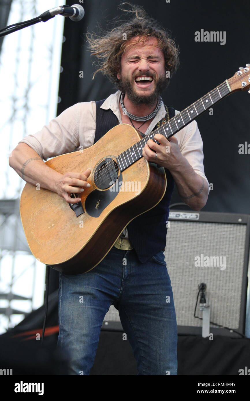 Musician John Butler is shown performing on stage during a "live