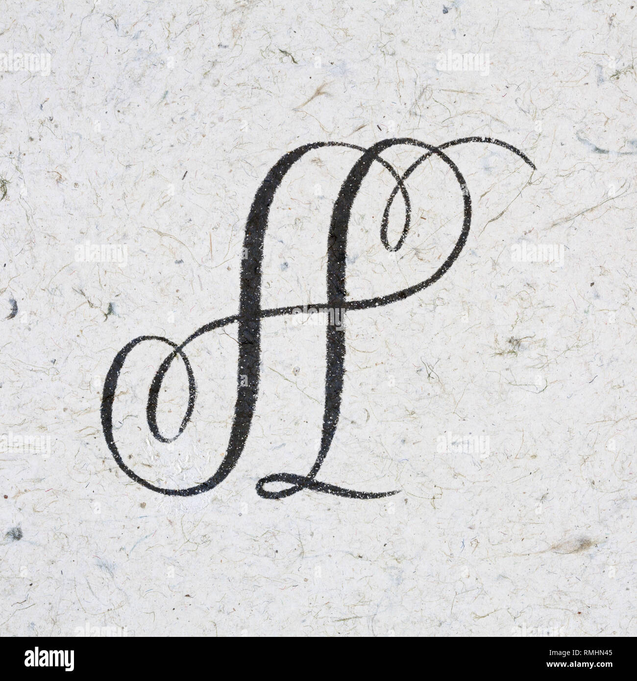 Elegant copperplate letter A written with bleeding ink on kraft paper