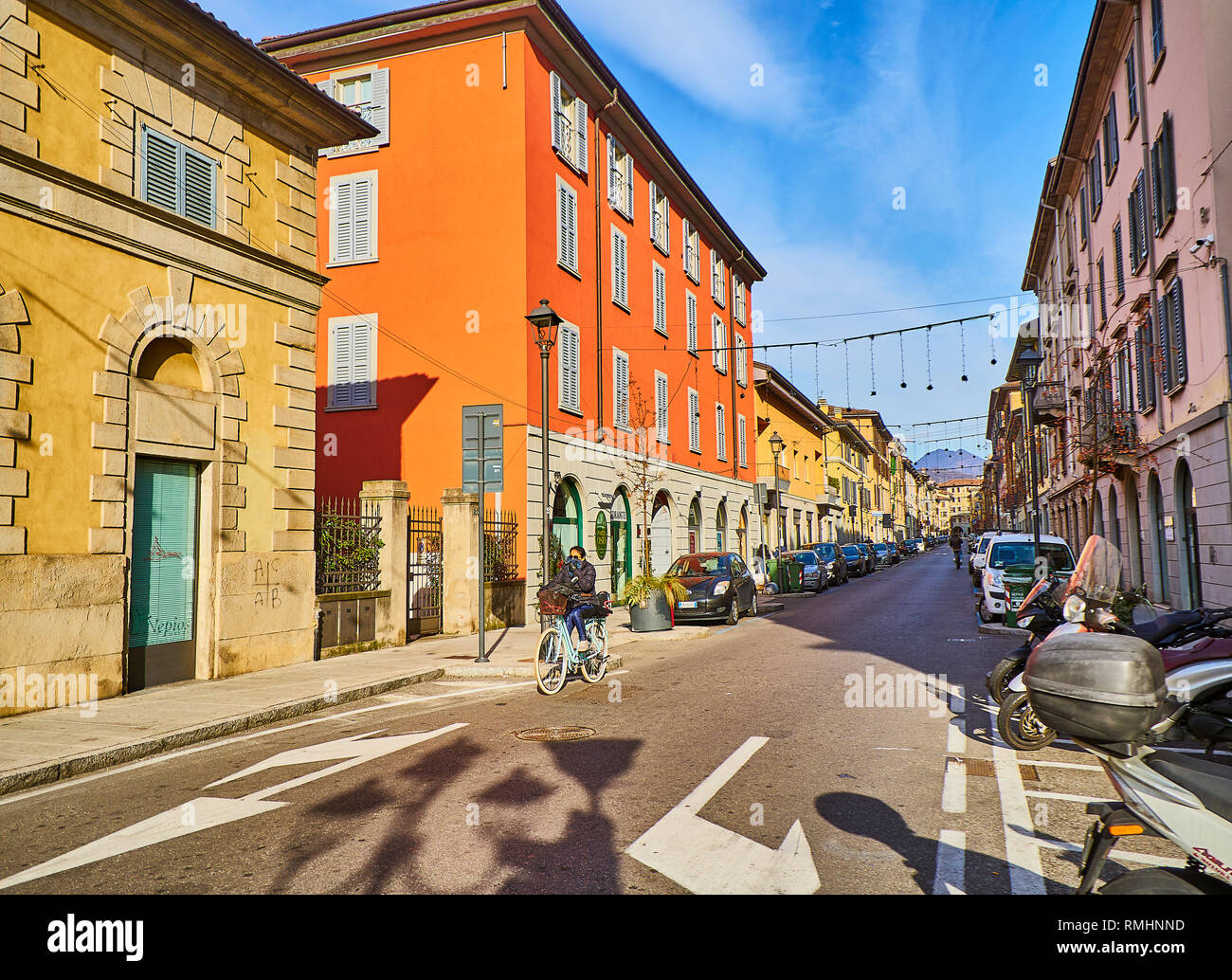 A cyclist crossing Via Giovanni Battista Moroni at Citta Bassa, Bergamo, Lombardy, Italy. View from Via Andrea Previtali street. Stock Photo