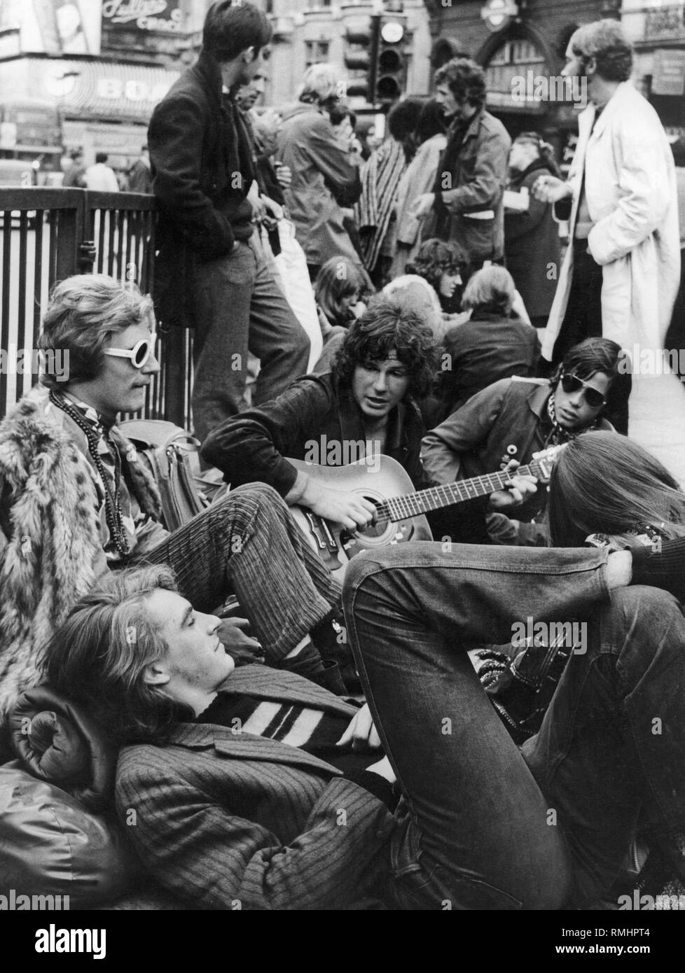 Young 'bums' on the ground, near a subway station in London. Stock Photo