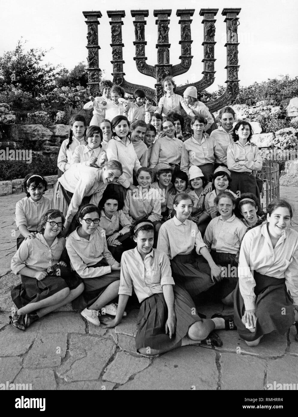 An Israeli school class at the Menorah by German sculptor Benno Elkan. The seven-branched candelabrum has stood in front of the Knesset, the Israeli parliament, in Jerusalem since 1966. Stock Photo