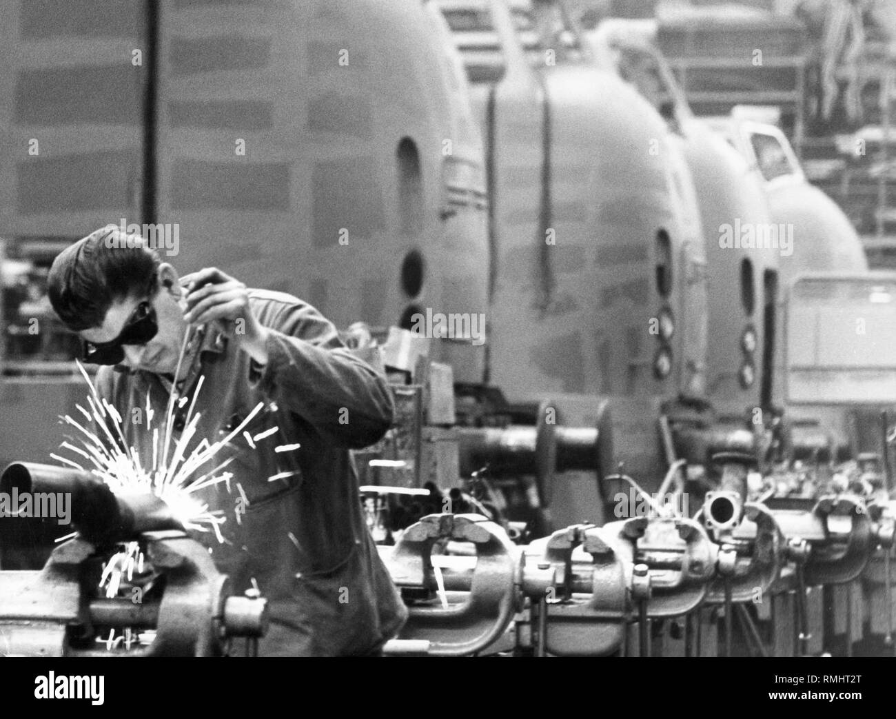 Man doing welding work in a locomotive factory. Undated photo. Stock Photo