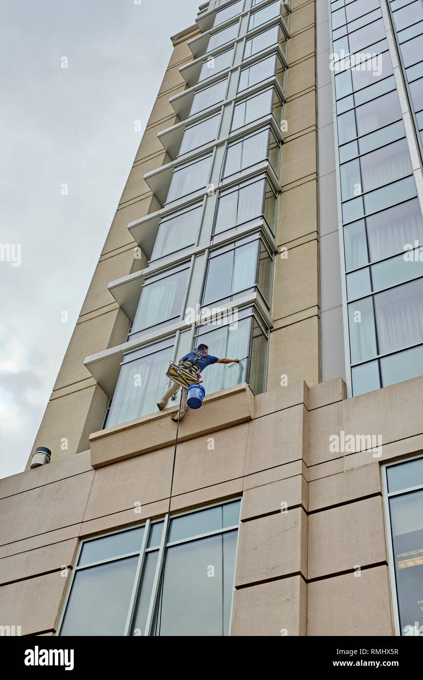 Window washer cleaning the outside windows of a high rise building from