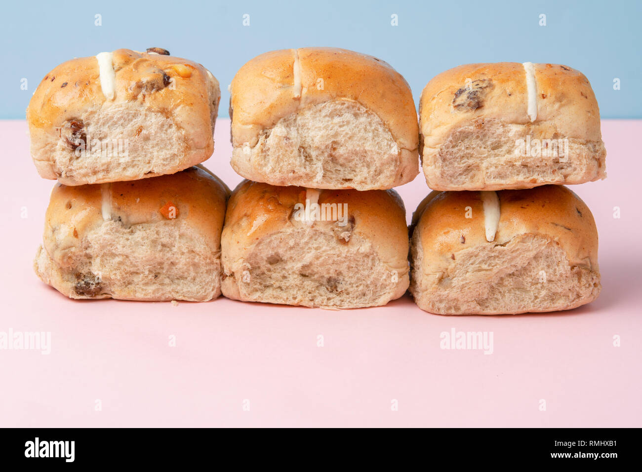 Six hot cross buns, traditional British Easter food on pink and blue ...