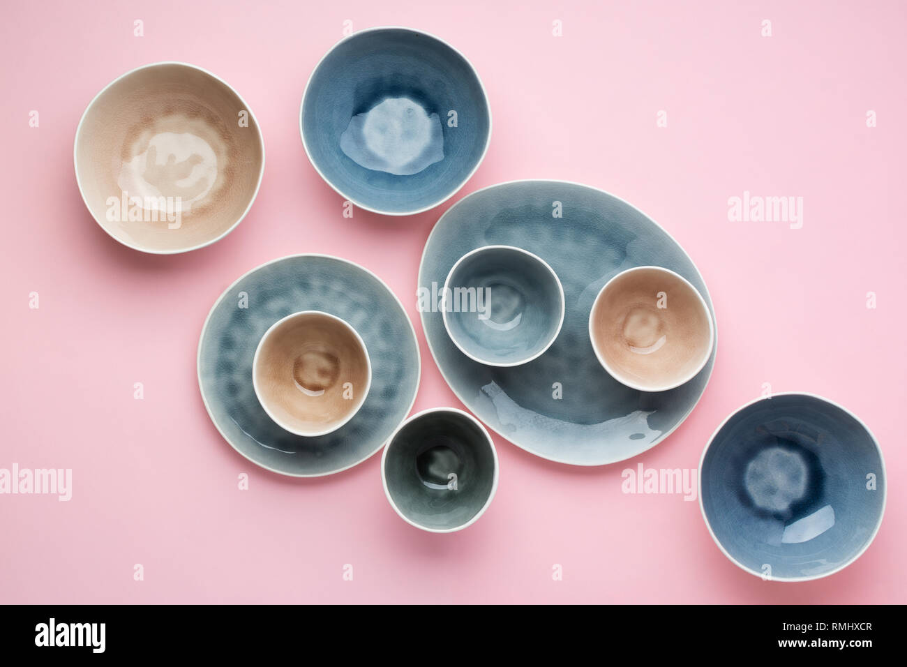 Beautiful blue, grey, beige dinnerware, plates bowls on pink table, top