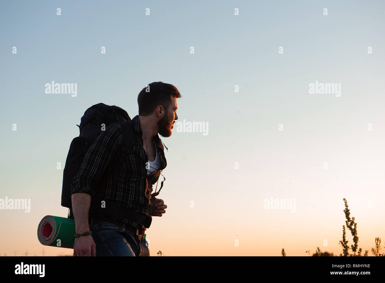 Traveler with backpack standing on a rock and enjoying sunset Stock ...