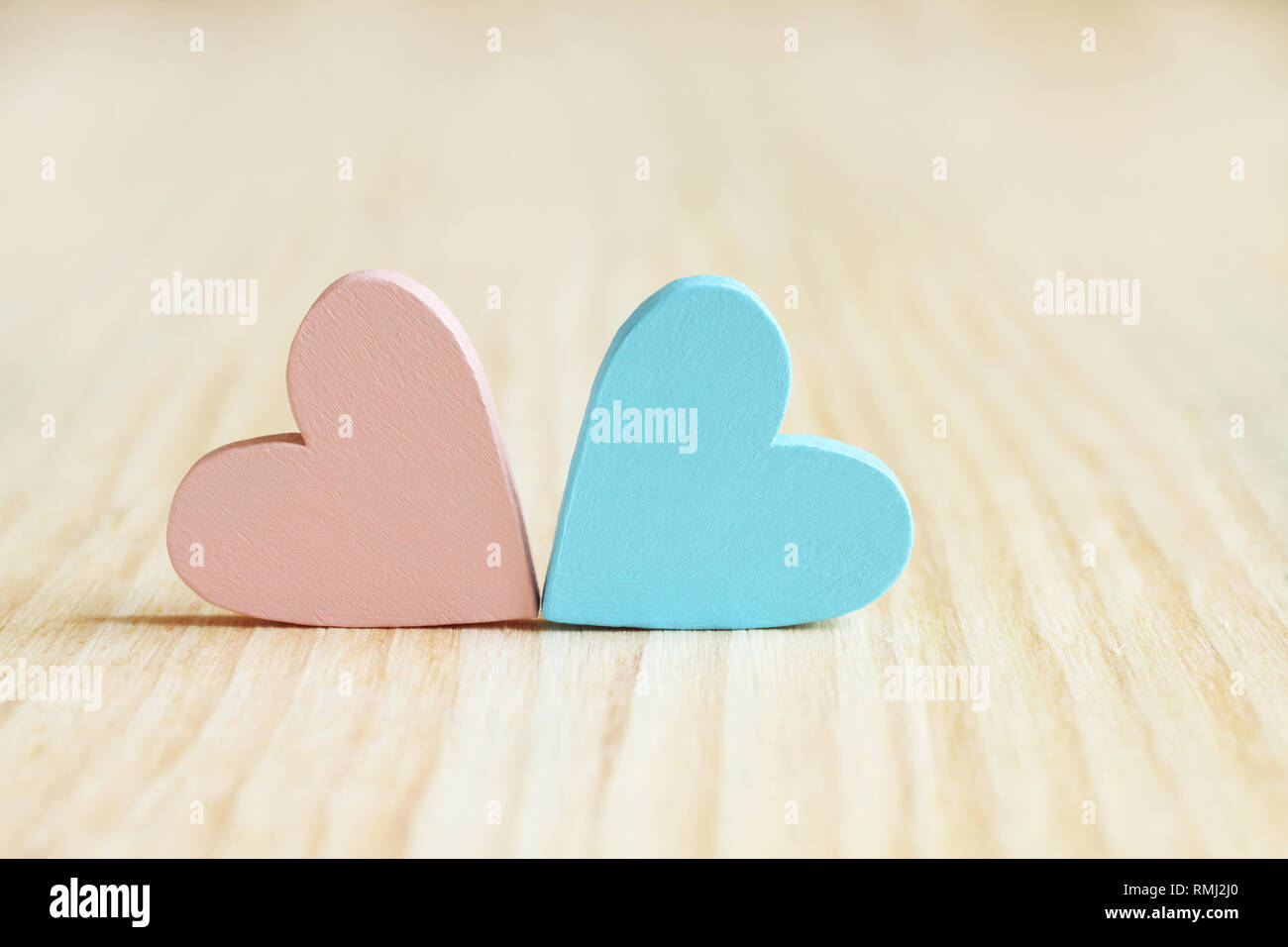 Light pink and light blue wooden hearts on wooden board Stock Photo - Alamy