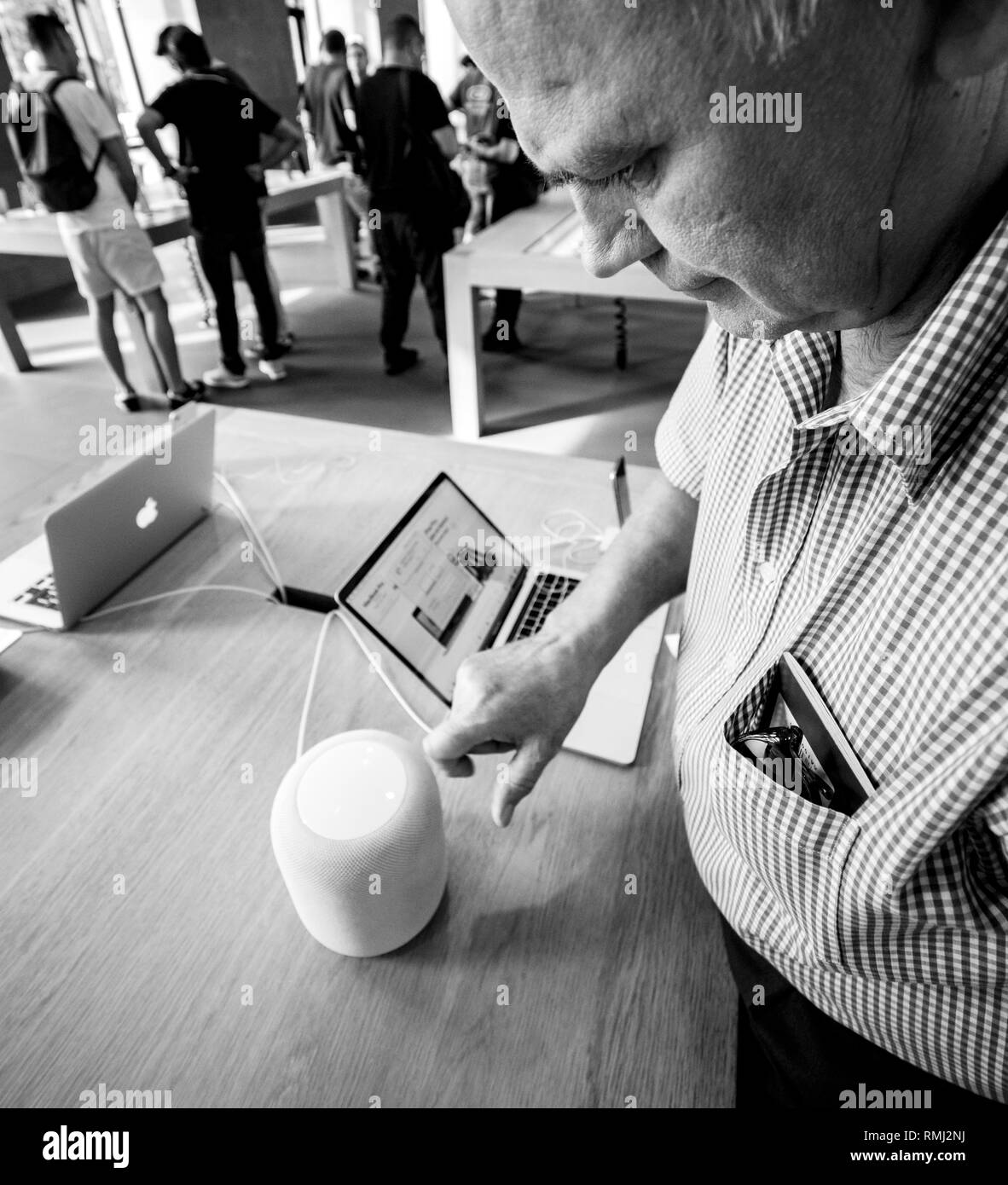 STRASBOURG, FRANCE - SEP 21, 2018: Curious senior man testing HomePod the smart speaker in Apple Store during the iPhone Xs and Xs Max preorder for Xr and Watch Series 4 wearable smartwatch - black and white Stock Photo