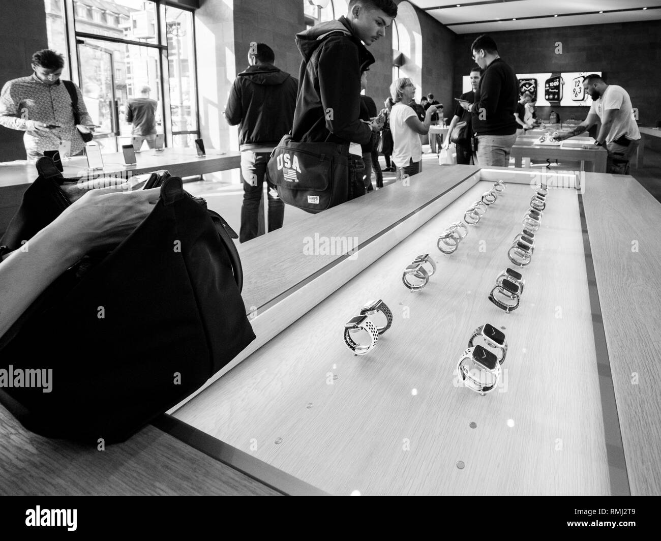 STRASBOURG, FRANCE - SEP 21, 2018: Apple Store with customers people buying admiring the new latest Apple Computers Watch Series 4 wearable smart watch - presentation in a row black and white Stock Photo