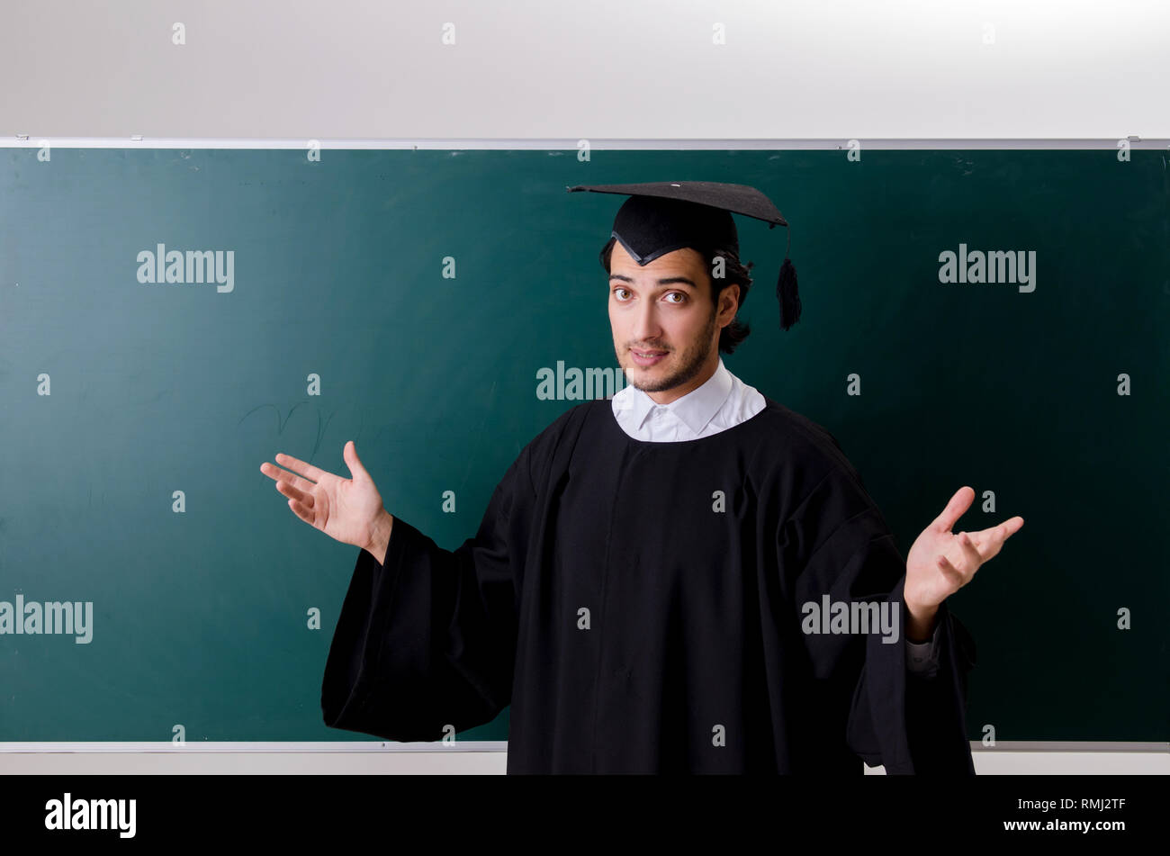 Graduate Front Use Graduate student in front of green board Stock Photo - Alamy