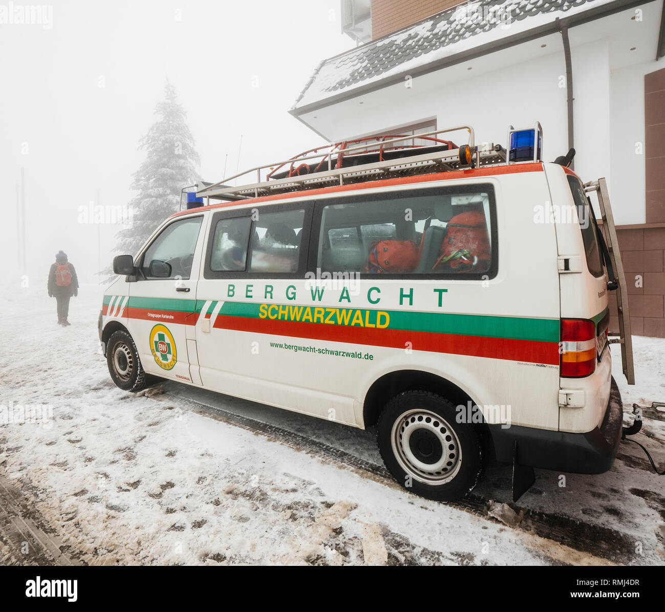 MUMMELSEE, GERMANY - JAN 26, 2019: Tourists woman near the Bergwacht Schwarzwald equipped van part of the German Red Cross (DRK-Bergwacht), whose primary functions are mountain rescue and nature conservation  Stock Photo