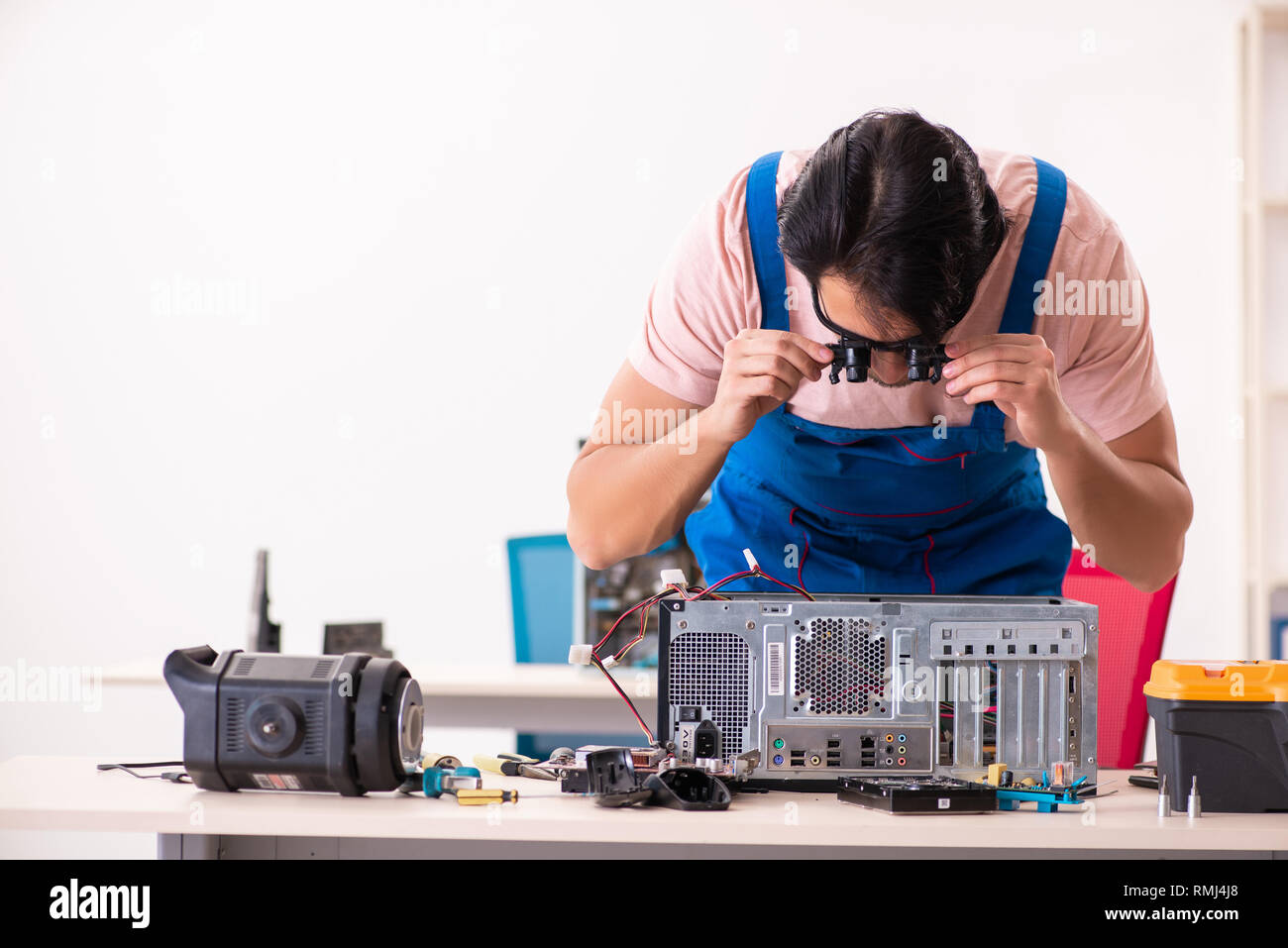 Young male contractor repairing computer Stock Photo - Alamy