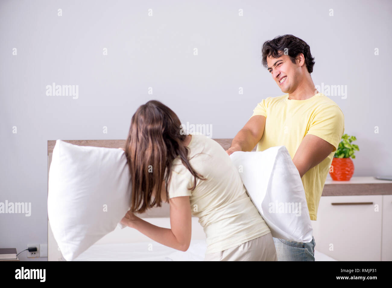 Wife and husband having pillow fight in bedroom Stock Photo Alamy