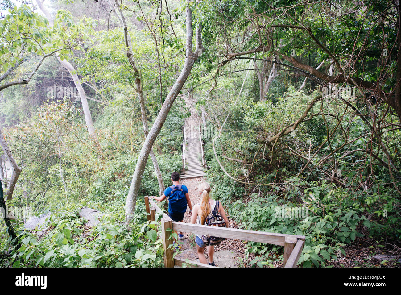 A young couple hikes through  the Parque Nacional Natural Tayrona in Santa Marta, Colombia Stock Photo