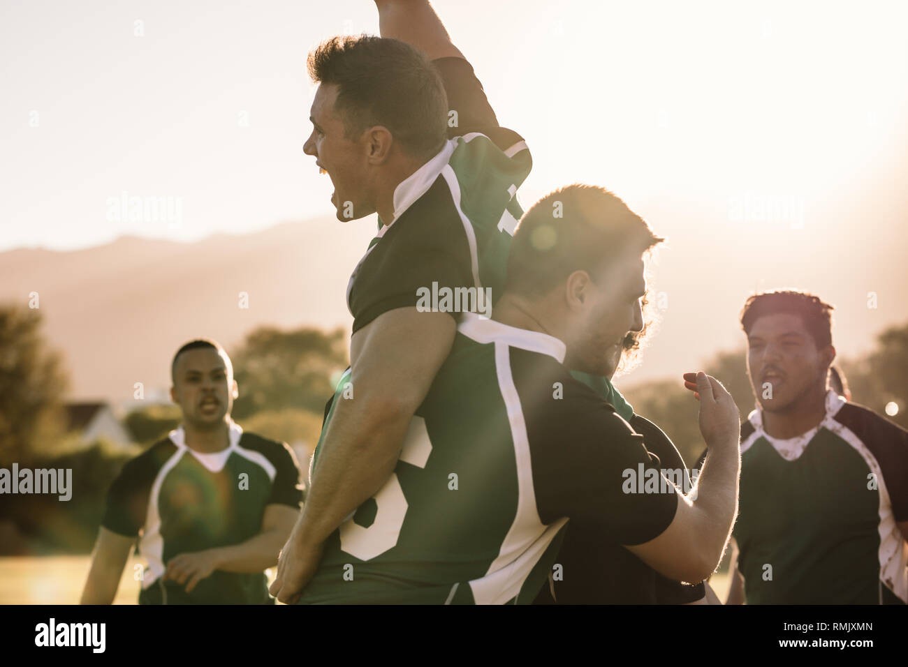 Excited young rugby players celebrating a win at the sports field. Rugby team enjoying after the