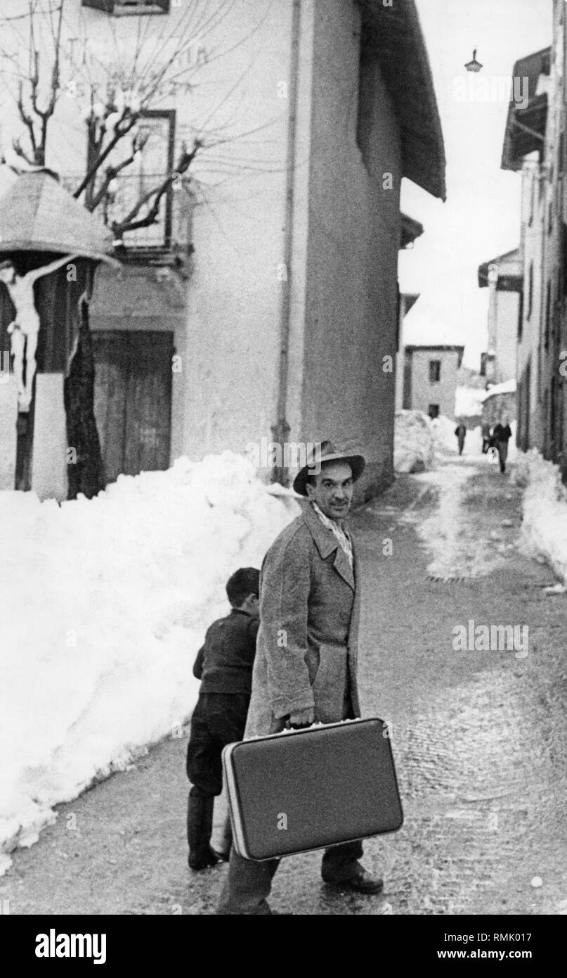 An Italian seasonal migrant worker is accompanied by his son to the bus to Germany, where he was supposed to work for another half a year at a silo plant in Frankfurt. Stock Photo