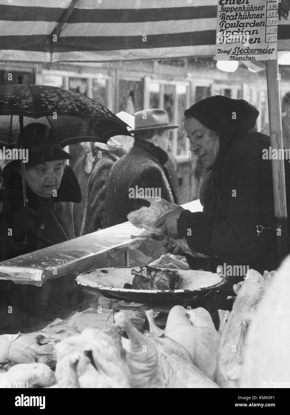 Market stall selling poultry and Christmas roast on the Viktualienmarkt in winter 1961. Stock Photo
