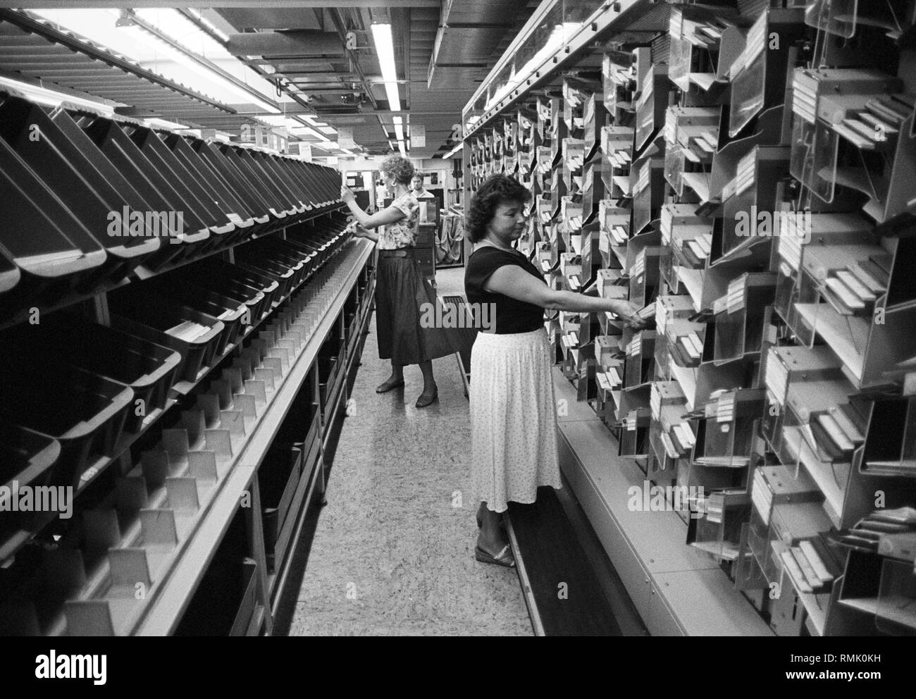 DEU , GERMANY : Two employees are sorting letters in a distribution centre of Deutsche Bundespost ( German Mail ) in Bonn , August 1988 Stock Photo