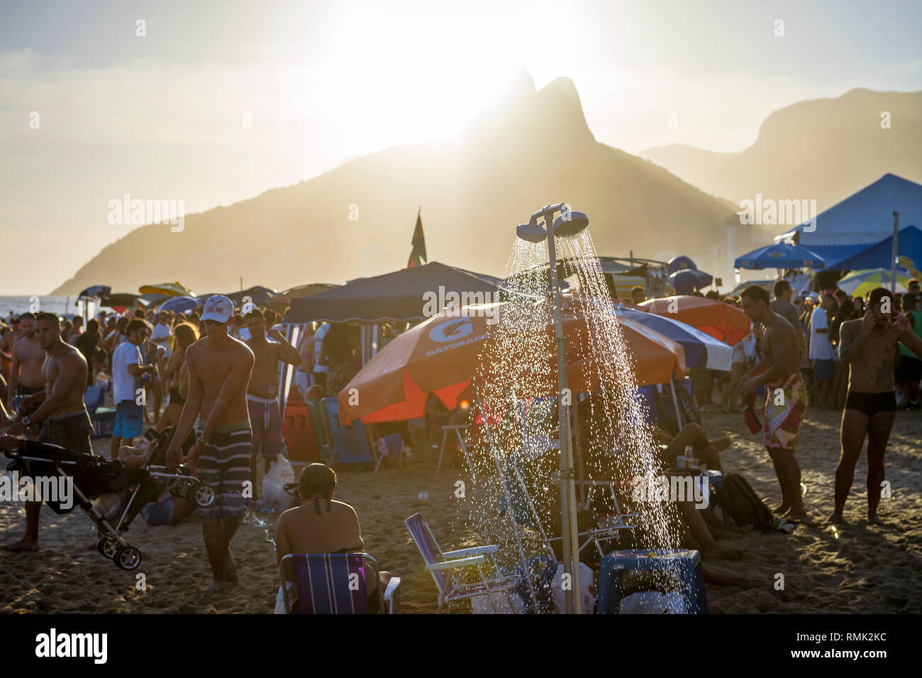 RIO DE JANEIRO - FEBRUARY 08, 2015: Showers stand ready to rinse the crowds leaving after the sun sets on a busy summer afternoon on Ipanema Beach. Stock Photo