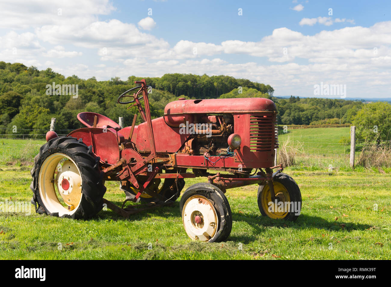 Old rusty vintage red tractor in agriculture landscape Stock Photo