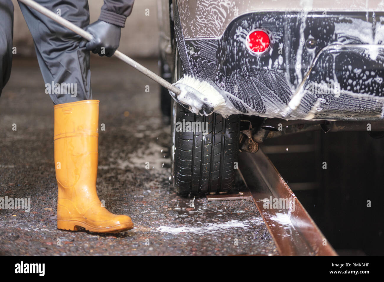 Professional car wash, cleaning car with soap and brush . Stock Photo