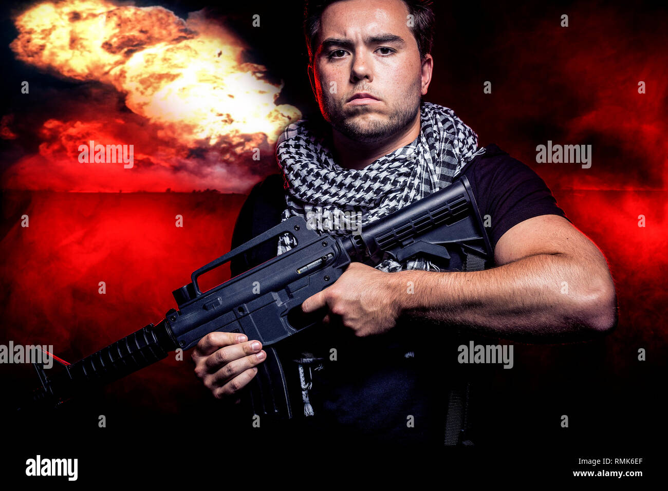 Soldier with a gun surviving bombs that are weapons of mass destruction or a nuclear war. The image depicts warfare and apocalyptic WW3. Stock Photo