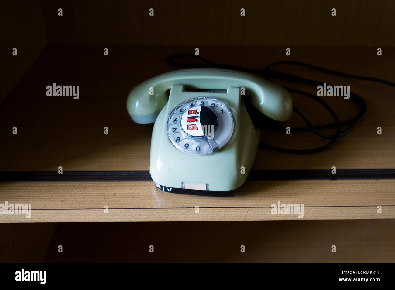 An old Polish rotary telephone with emergency sticker in Krakow, Poland. Stock Photo