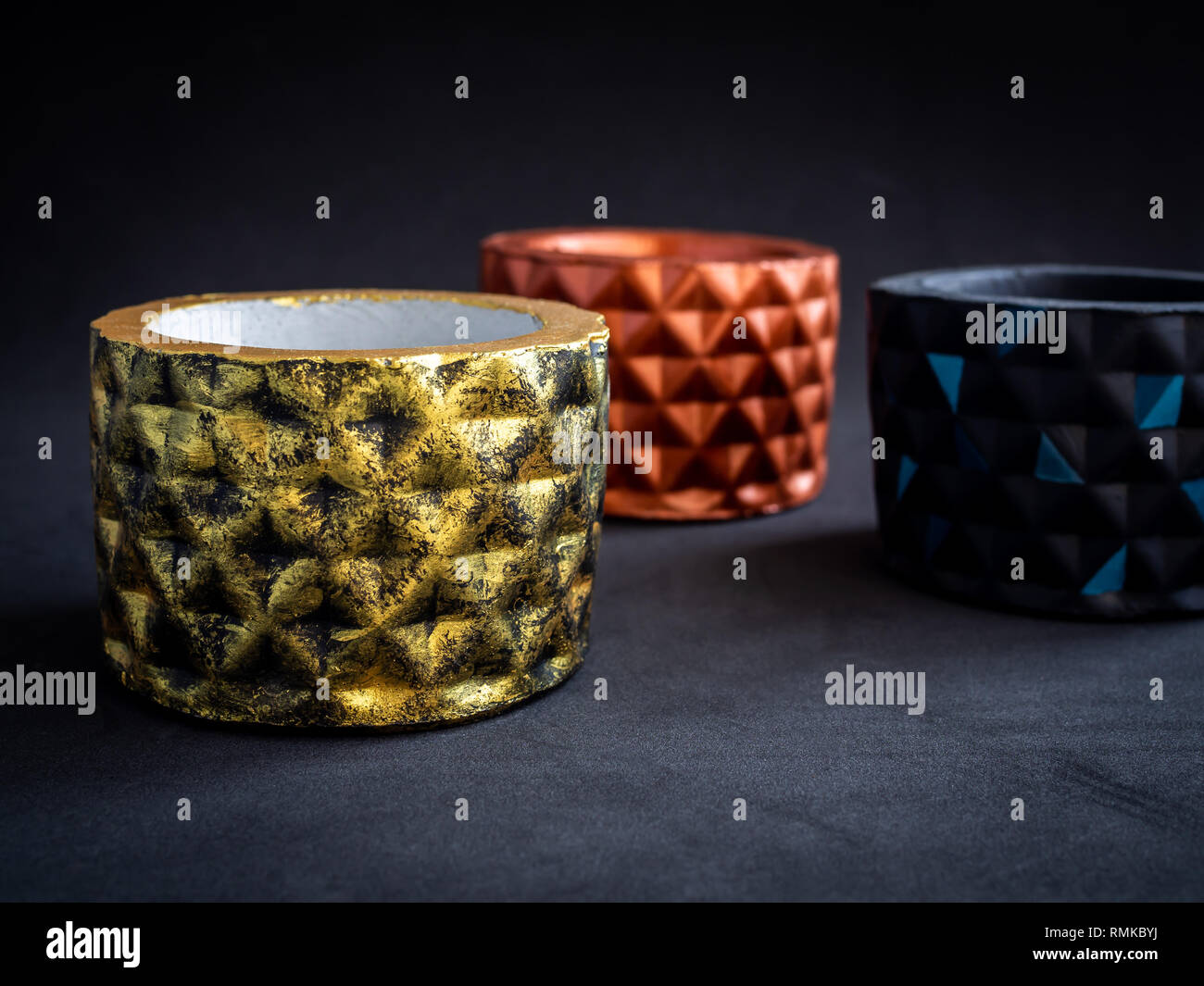 View of Metallic colour modern geometric concrete planter on dark background ...