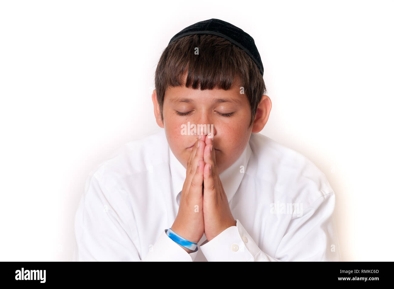 Jewish boy reading his Torah or prayer book isolated on white. Stock Photo