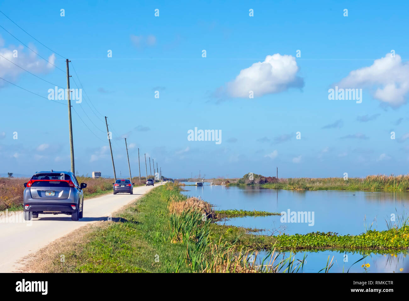 Line of cars slowly drive the canals  looking for  birds  on the Lake Apopka North Shore  Wildlfie Drive near Orlando Florida Stock Photo