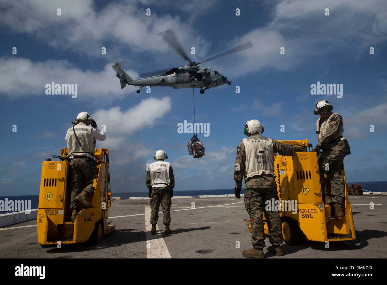 WESTERN PACIFIC (Feb. 7, 2019) U.S. Marines with the 13th Marine Expeditionary Unit (MEU), wait for an SH-60 Sea Hawk to land pallets during an aerial replenishment-at-sea aboard the San Antonio-class amphibious transport dock USS Anchorage (LPD 23) while on a deployment of the Essex Amphibious Ready Group (ARG) and 13th MEU. The Essex ARG/13th MEU is a capable and lethal Navy-Marine Corps team deployed to the U.S. 7th Fleet area of operations to support regional stability, reassure partners and allies and maintain a presence postured to respond to any crisis ranging from humanitarian assistan Stock Photo