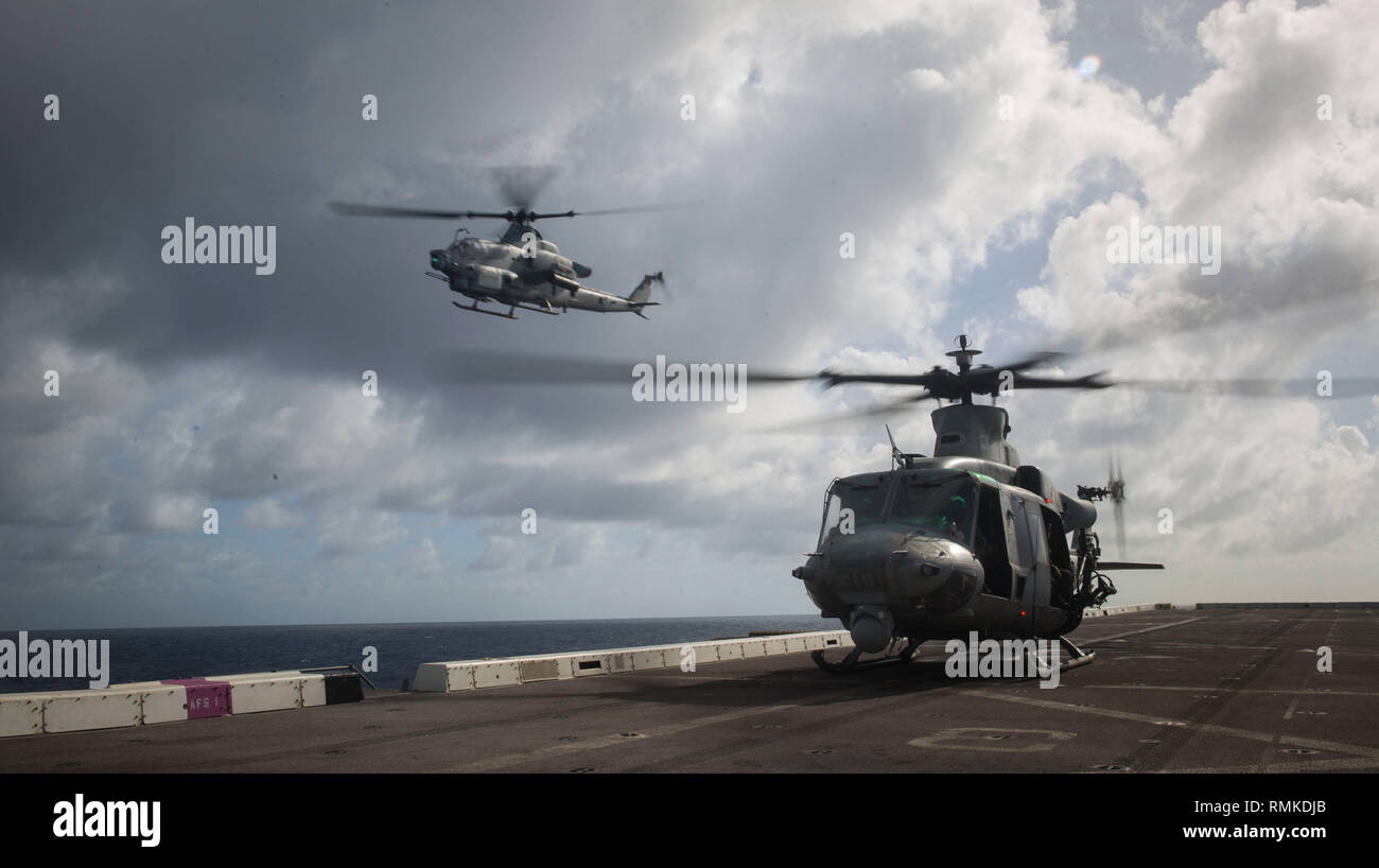 PHILIPPINE SEA (Feb. 5, 2019) A U.S. Marine Corps AH-1Z Viper, left, and a UH-1Y Venom, both with Marine Medium Tiltrotor Squadron 166 Reinforced, 13th Marine Expeditionary Unit (MEU), conduct flight operationss aboard the San Antonio-class amphibious transport dock USS Anchorage (LPD 23) while on a deployment of the Essex Amphibious Ready Group (ARG) and 13th MEU. The Essex ARG/13th MEU is a capable and lethal Navy-Marine Corps team deployed to the U.S. 7th Fleet area of operations to support regional stability, reassure partners and allies and maintain a presence postured to respond to any c Stock Photo