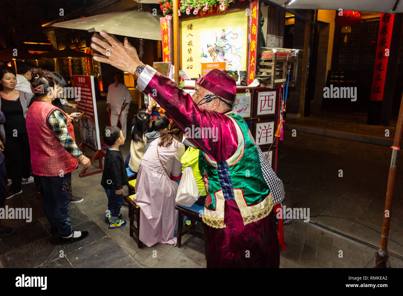 Chinese narrator gesticulates at a Peking peep show at a park in Shenzhen, China Stock Photo